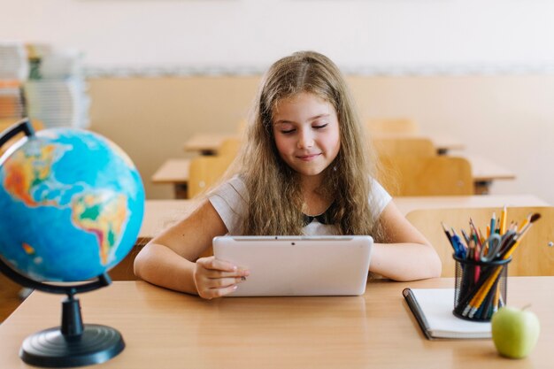 Schulmädchen mit Tablette im Unterricht