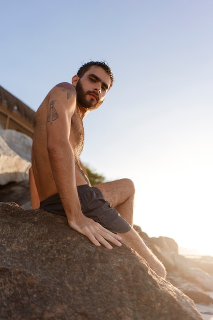 Kostenloses Foto seitenansicht eines mannes mit behaarter brust am meer