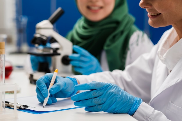 Kostenloses Foto seitenansicht von wissenschaftlerinnen bei der arbeit im labor