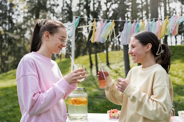 Kostenloses Foto seitenansichtmädchen, die limonade trinken