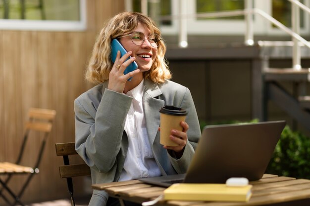 Smiley-Frau, die am Telefon mittlerer Schuss spricht