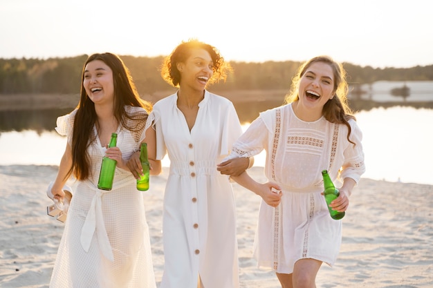 Kostenloses Foto smiley-frauen der vorderansicht am strand