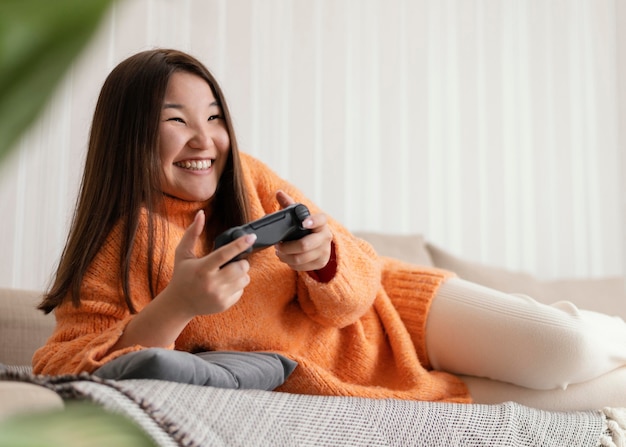 Smiley-Mädchen, das Videospiel mit Controller spielt