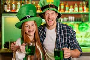 Kostenloses Foto smiley mann und frau feiern st. patricks tag an der bar