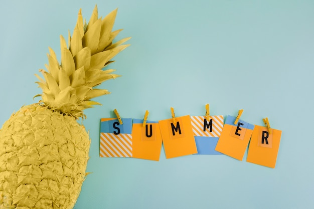 Kostenloses Foto sommeraufkleber mit wäscheklammer nahe der gemalten gelben ananas auf blauem hintergrund