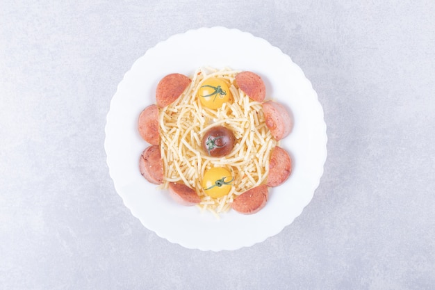 Kostenloses Foto spaghetti mit bratwürsten und tomaten in weißer schüssel.