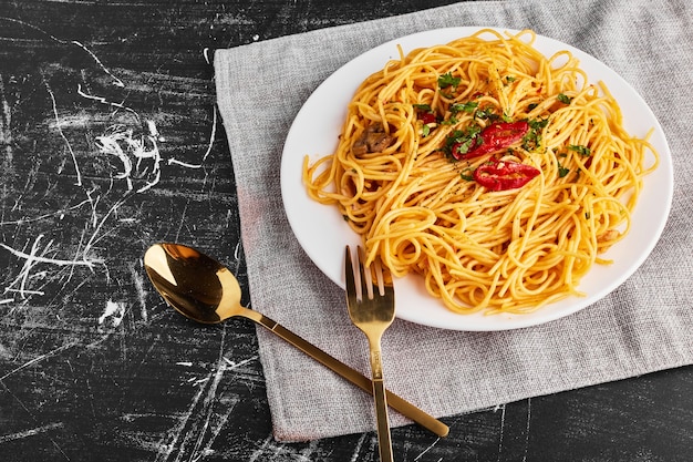 Kostenloses Foto spaghetti mit kräutern und gemüse in einem weißen teller, draufsicht