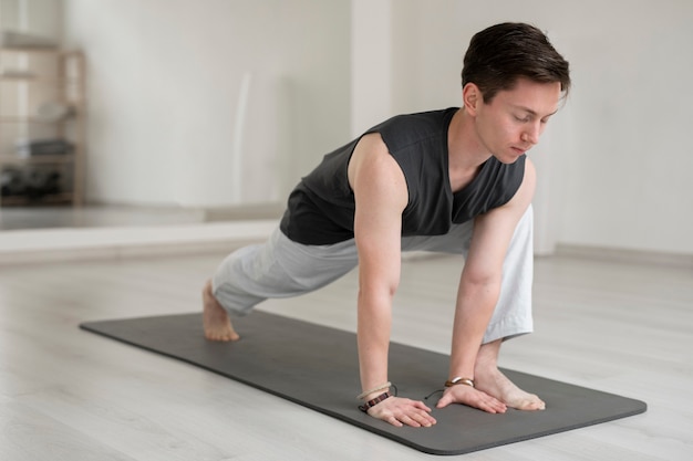 Kostenloses Foto spiritueller junger mann, der yoga in sportkleidung praktiziert