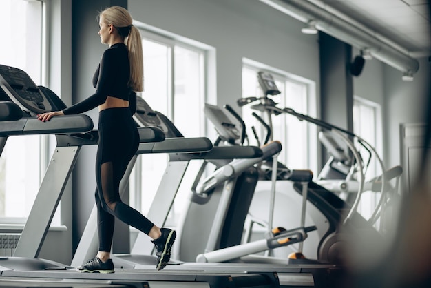 Kostenloses Foto sportliche frau, die im fitnessstudio auf dem laufband läuft