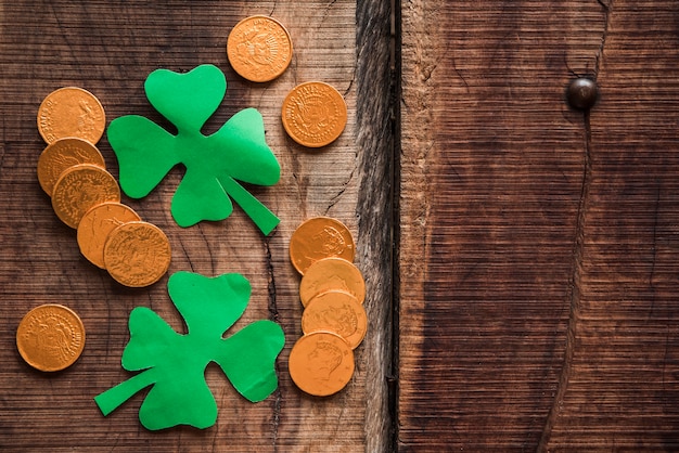 Kostenloses Foto stapel von münzen und von grünbuchshamrocks auf holztisch