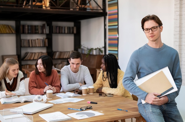 Student posiert während einer Gruppenstudie mit Kollegen