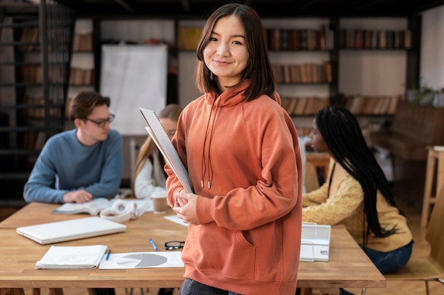 Kostenloses Foto student posiert während einer gruppenstudie mit kollegen