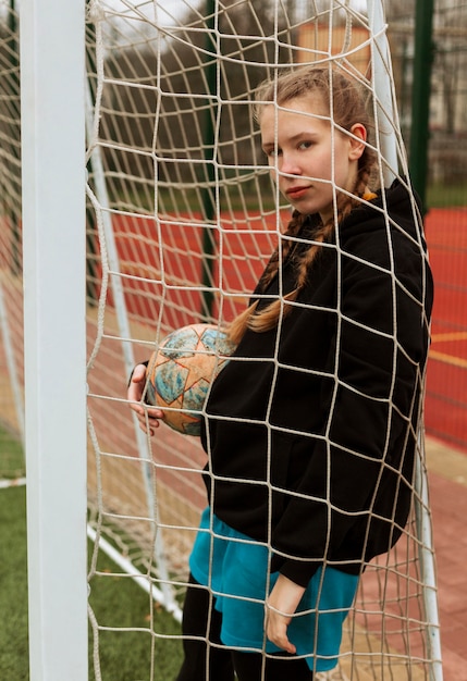 Kostenloses Foto teenager, der mit einem ball draußen aufwirft