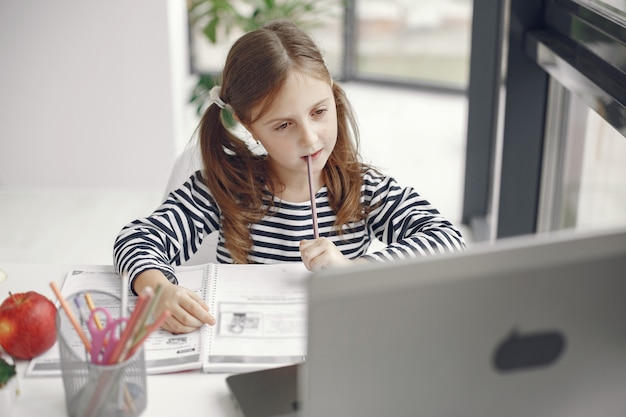 Kostenlose Foto teenager-mädchen, das laptop betrachtet. kinder in der quarantäne-isolationsphase während der pandemie. heimunterricht. soziale distanzierung. online-schultest.