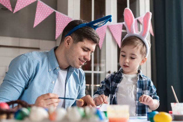 Vater bringt seinem Sohn bei, wie man Eier für Ostern malt