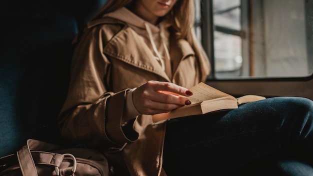 Kostenloses Foto verschwommene frau, die ein buch innerhalb eines zuges liest