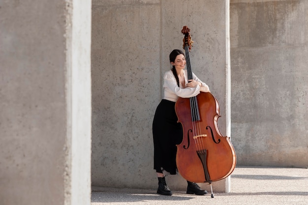 Kostenloses Foto voll erschossene frau mit instrument