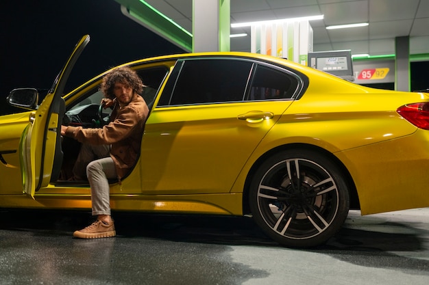 Kostenloses Foto voll erschossener mann an der tankstelle