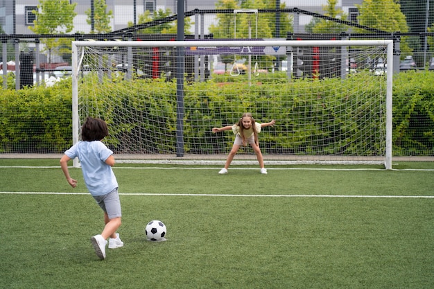 Kostenloses Foto voll geschossene kinder, die fußball spielen