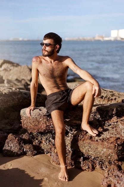 Kostenloses Foto vollbild-mann mit behaarter brust am meer