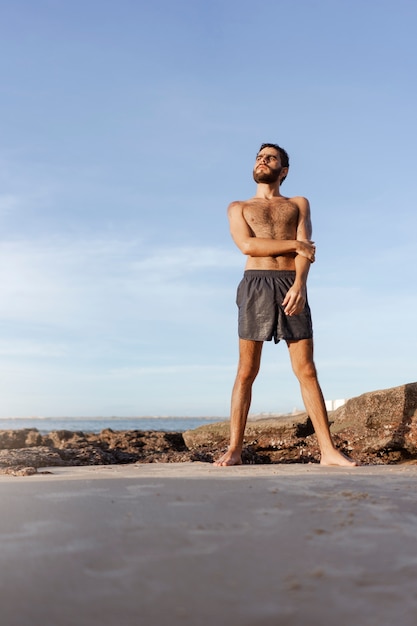 Kostenloses Foto vollbild-mann mit behaarter brust am meer