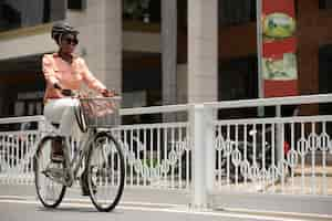 Kostenloses Foto vollbildfrau, die mit dem fahrrad zur arbeit geht