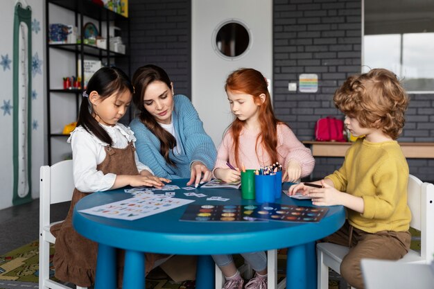 Voller Schuss Kinder und Lehrer am Tisch