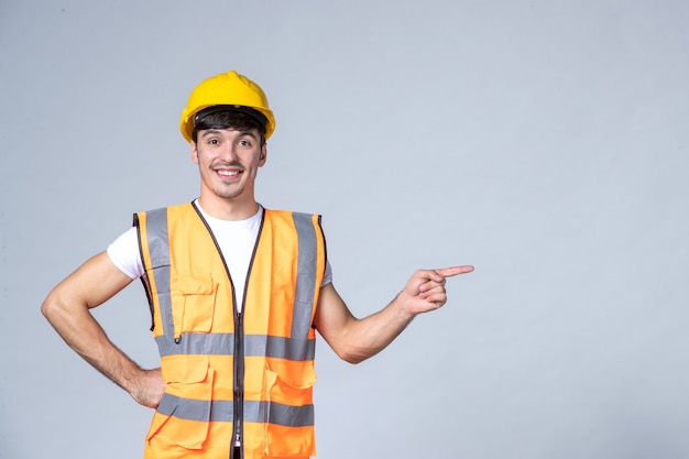 Kostenloses Foto vorderansicht des männlichen baumeisters in uniform an der weißen wand