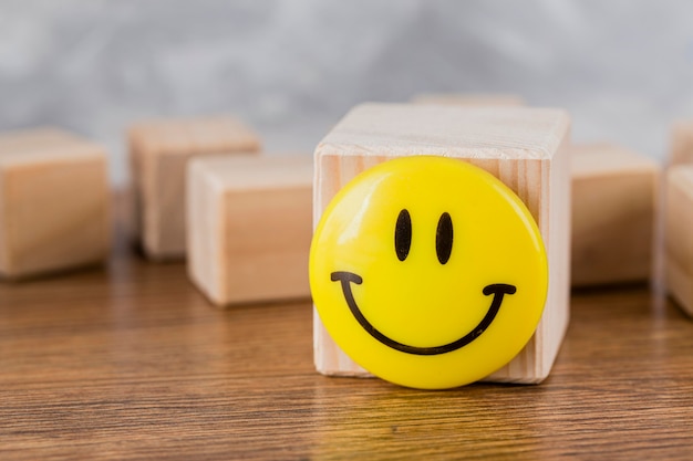 Kostenloses Foto vorderansicht des smileygesichtes auf holzblock