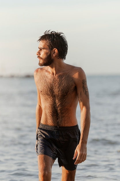 Kostenloses Foto vorderansicht eines mannes mit behaarter brust am meer