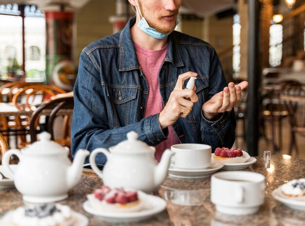 Vorderansicht Mann, der seine Hände am Restaurant desinfiziert