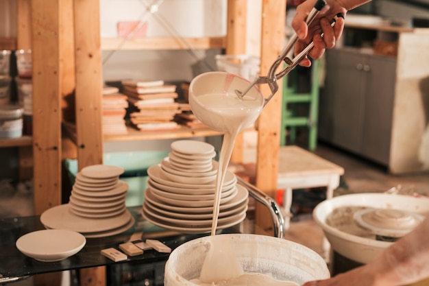 Weibliche Handwerkerin, welche die Schüssel hält mit Zange malt