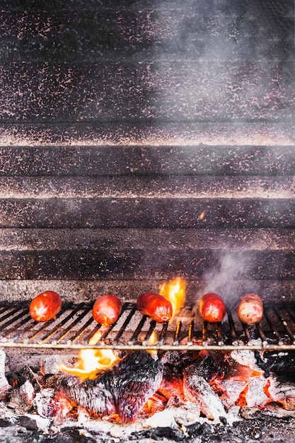 Kostenloses Foto würstchen auf dem grill mit flammen