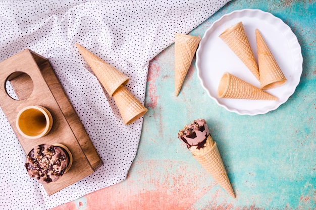 Kostenlose Foto zusammensetzung von leeren oblatenschalen und -eiscreme in den waffelkegeln