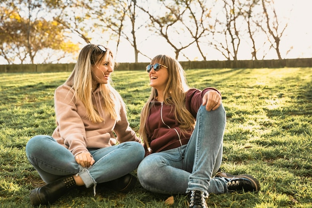 Zwei Frauen im Freien sitzen auf Gras