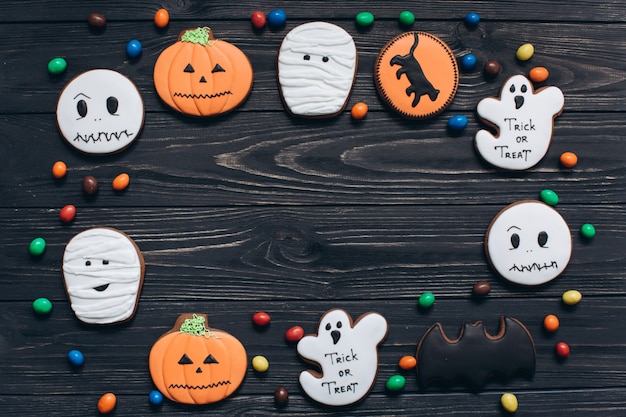 A cores de doces e assustadores gingerbreads para Halloween em um fundo de madeira preto.