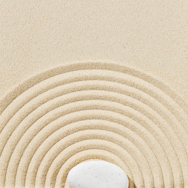 Ästhetischer minimaler Hintergrund mit Zen-Steinen auf Sand Muster im japanischen Zen-Garten mit Kreisen