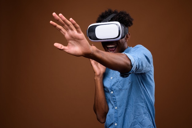 Afrikanischer Mann, der virtuelle Realität genießt, während er VR-Brille benutzt