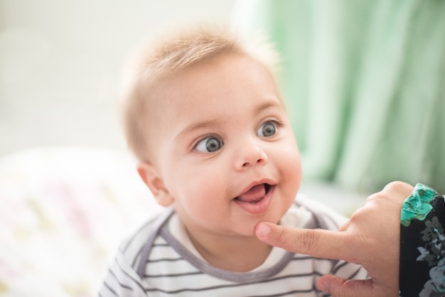 Bebê sorrindo - dente de leite - mão da mãe