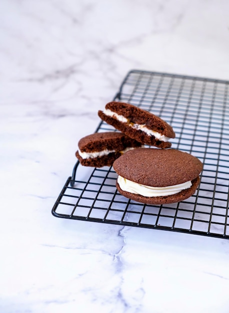 Foto biscoitos de sanduíche de chocolate caseiros fundo de mármore claro foco seletivo