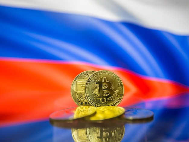 Bitcoin-Goldmünze und defokussierte Flagge von Russland-Hintergrund. Konzept der virtuellen Kryptowährung.