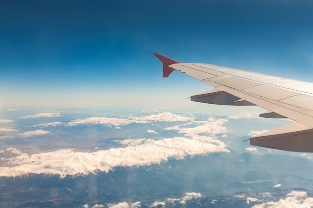 Foto blick aus dem fenster des flugzeugs, das über die berge fliegt