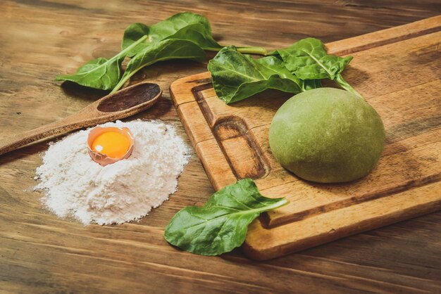 Bolinho de massa verde para macarrão com ingredientes na mesa