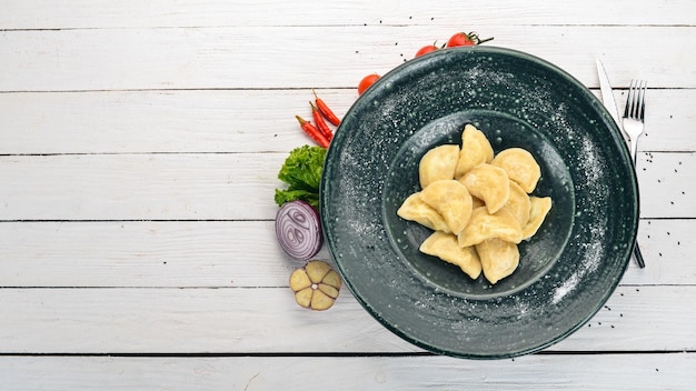 Foto bolinhos com batatas em um prato cozinha tradicional ucraniana em uma mesa de madeira vista superior copiar espaço