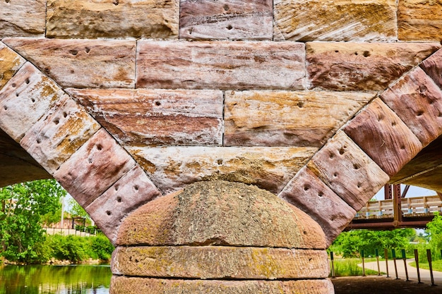 Brilhante ponte de tijolos de pedra com arcos geométricos parciais de cores brancas e douradas rústicas