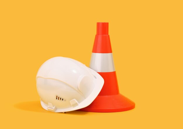 Foto capacete de proteção da cabeça branco e cone de construção laranja conceito de construção