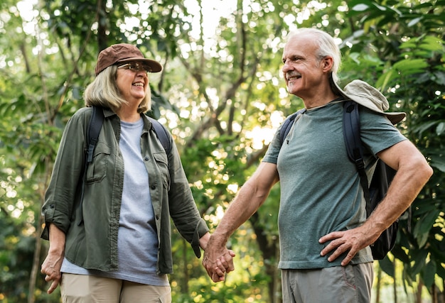 Casal de idosos de mãos dadas na floresta