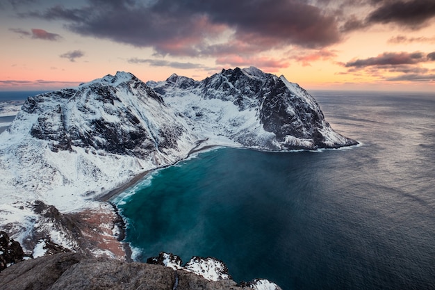 Cenário da montanha Ryten com praia Kvalvika no pôr do sol nas ilhas Lofoten