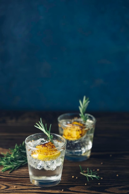 Foto charred lemon rosemary e coriander gin and tonic é um sabor perfeitamente equilibrado refrescante coquetel em fundo escuro de perto