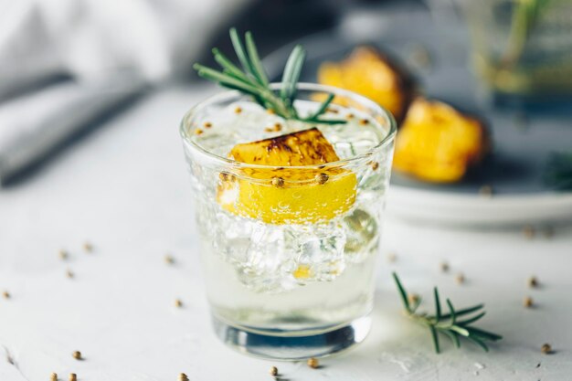 Foto charred lemon rosemary e coriander gin e tonic é um sabores são perfeitamente equilibrados refrescante coquetel em fundo claro de perto bebidas de verão e coquetéis alcoólicos